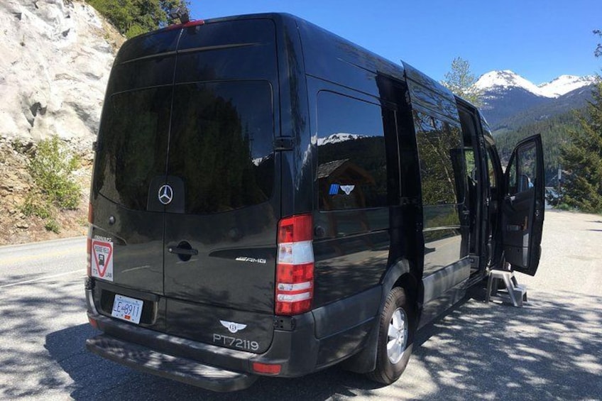 Ein schwarzer Mercedes-Van auf einer Straße vor einer Bergkulisse. 2