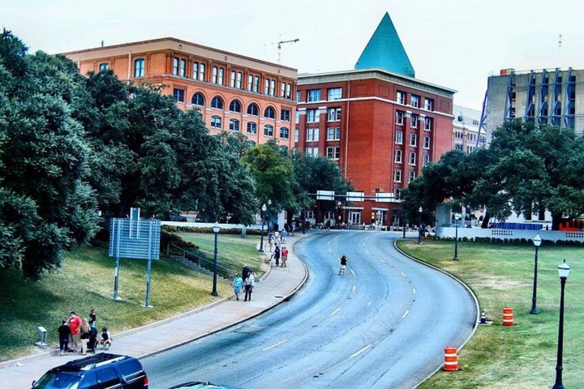 A curved road with a building with a green roof in the background. 3