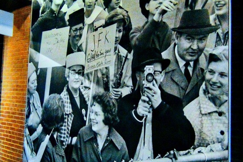 A historical photograph with people holding signs and a camera. 5