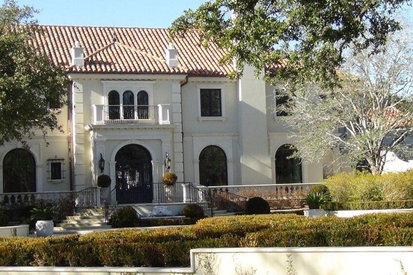 A white building with a red-tiled roof, arched windows, and a central entrance. 5