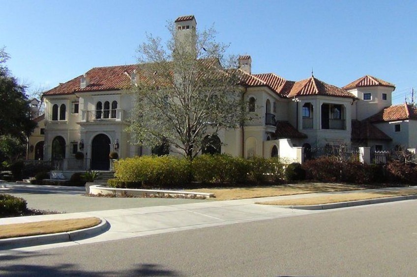A large, historic house with a red-tiled roof, arched windows, and a prominent tower. 5