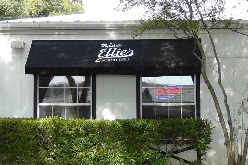 A storefront with a black awning and a neon 'OPEN' sign. 2
