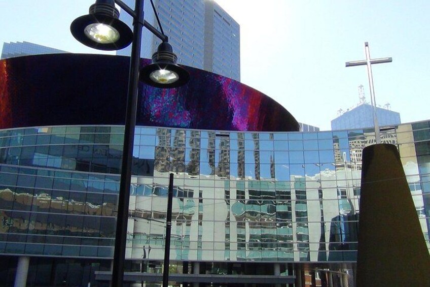 Un edificio moderno con finestre a vetro riflettente, una croce ben visibile e un lampione di strada. 3