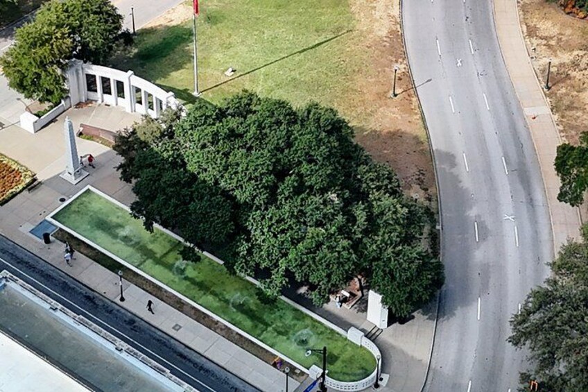 An aerial view of a park with a grassy area, a curved road, and a white building with columns. 3