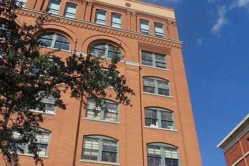 A tall brick building with multiple windows and a clear blue sky. 2