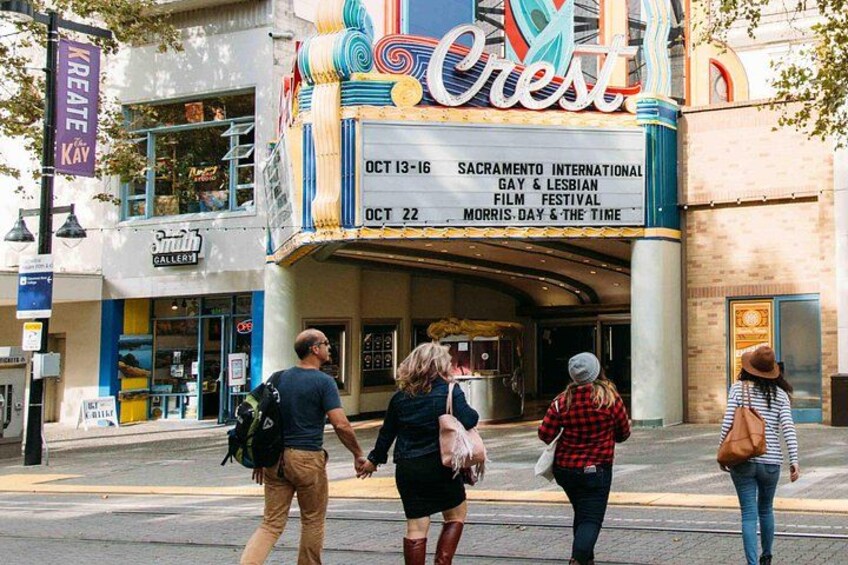 A theater marquee with event listings and a street scene with pedestrians. 1