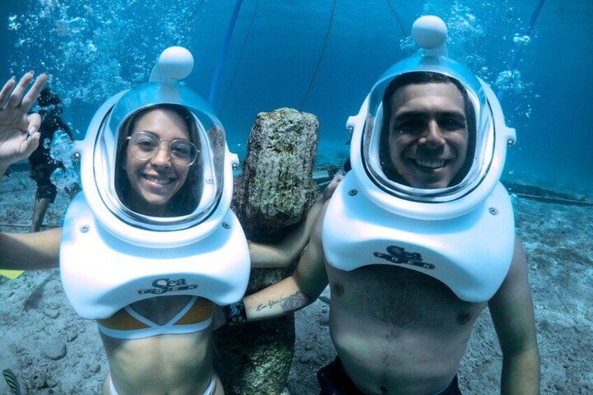 Two people in scuba diving gear underwater, with a diver in the background. 3