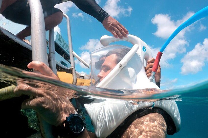 A person in a snorkeling mask and snorkel, being assisted by another person. 2