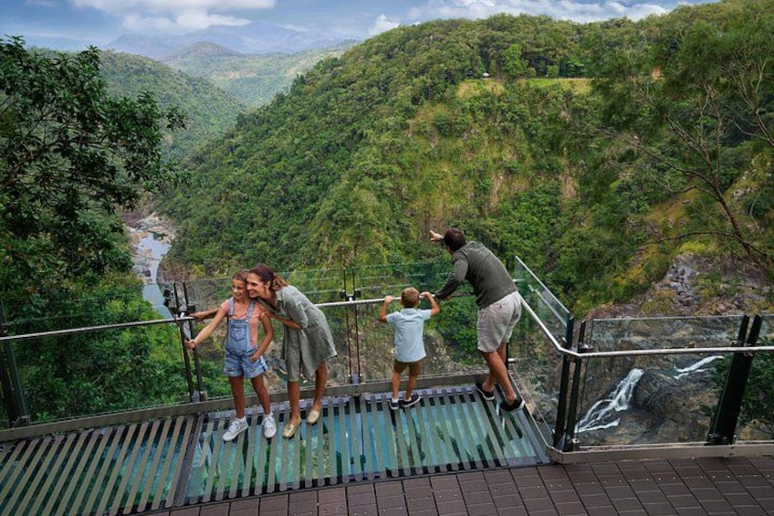 A group of people on a viewing platform overlooking a river and forested valley. 2