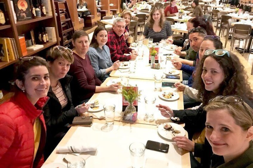 En gruppe mennesker sidder ved et bord i en restaurant. 4