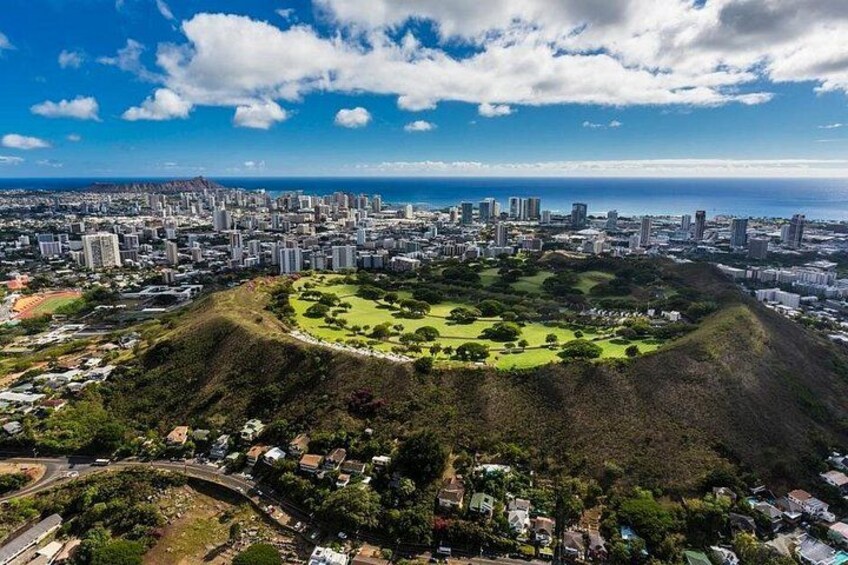 A cityscape with a large hill in the foreground and a dense urban area in the background. 3