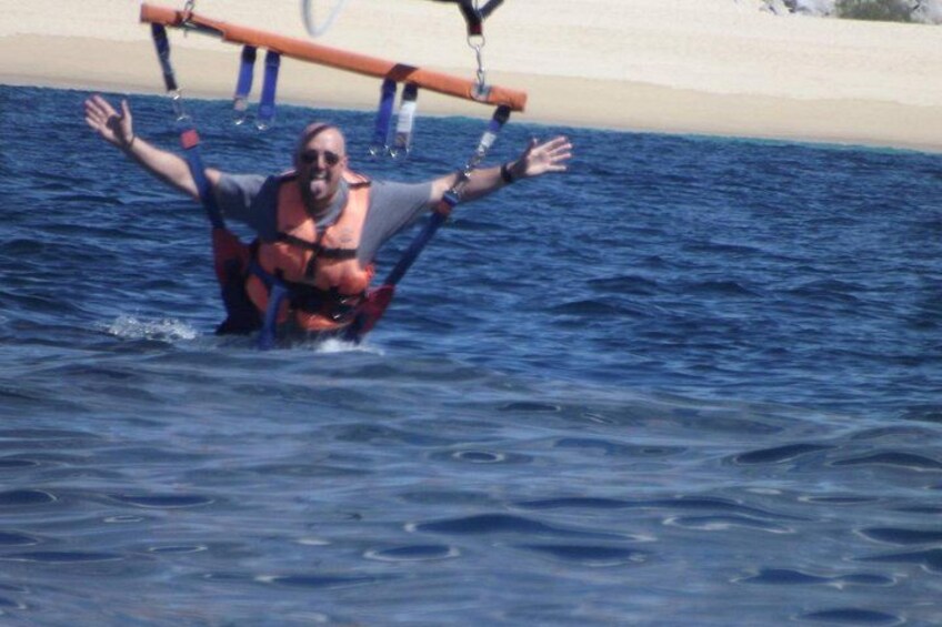 A person in a life jacket floating in the water with a boat in the background. 3