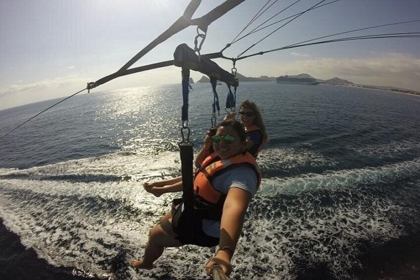 A person windsurfing on a body of water with waves and distant landforms. 2