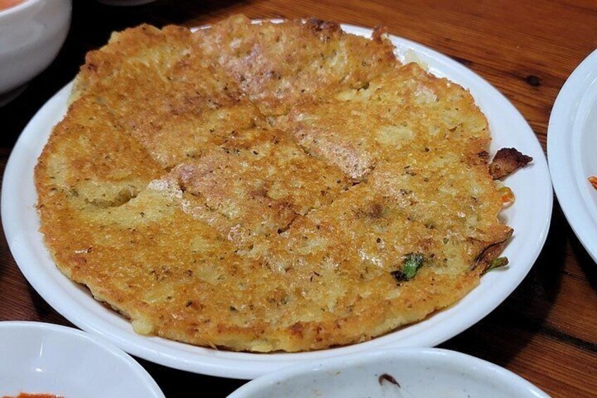 A large, round, golden-brown pancake on a white plate. 3