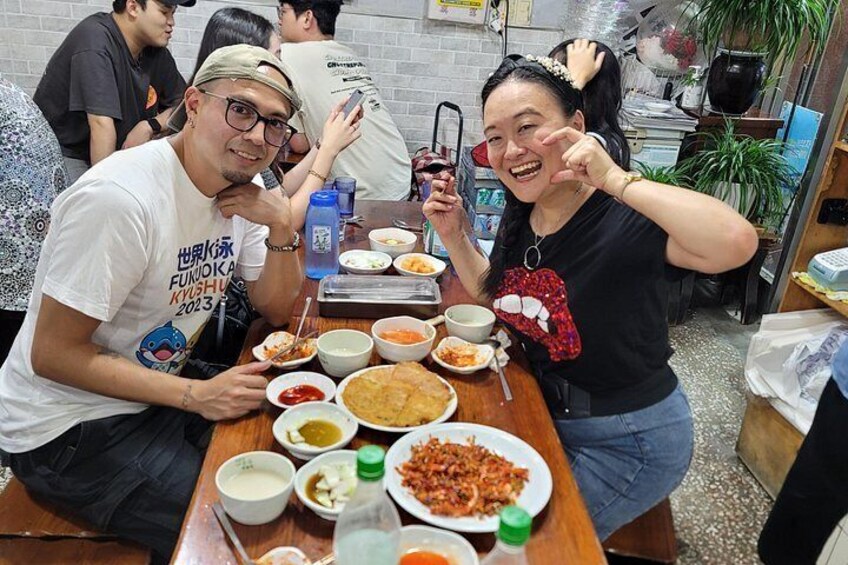 A group of people dining at a restaurant with various dishes on the table. 4