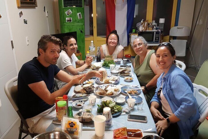 A group of people sitting around a table with various dishes and drinks. 1