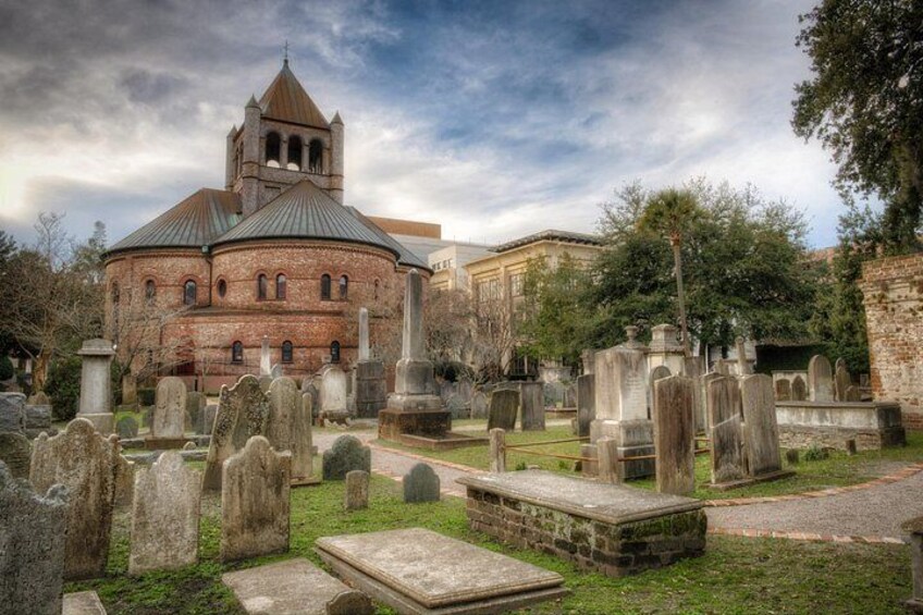 A historic church with a bell tower, surrounded by a cemetery with headstones. 2