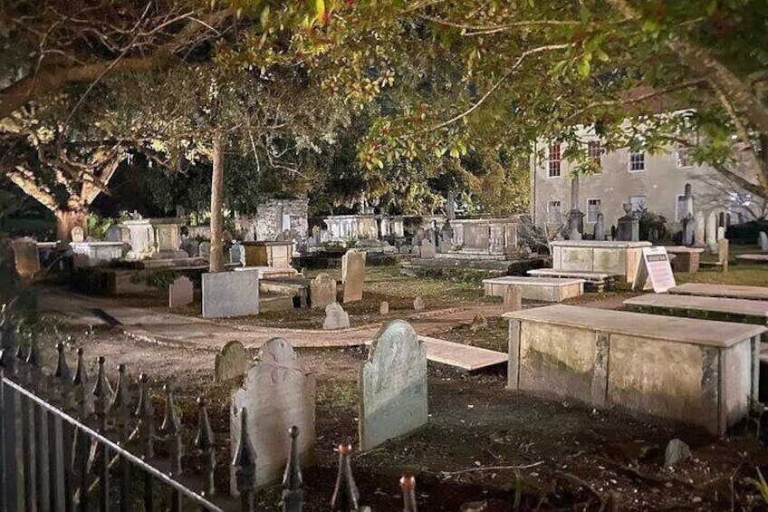 A cemetery with gravestones and tombstones under trees. 4