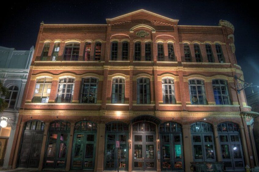 A large, illuminated building with multiple windows and a prominent entrance. 4