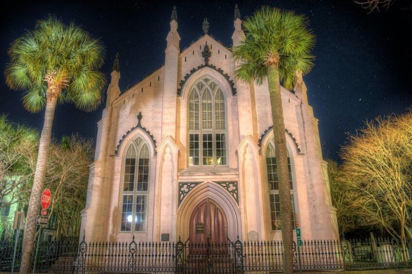 A historic church with arched windows and a central entrance, surrounded by palm trees. 5