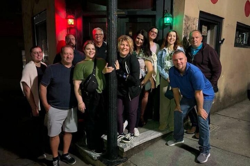 A group of people standing outside a building at night. 3