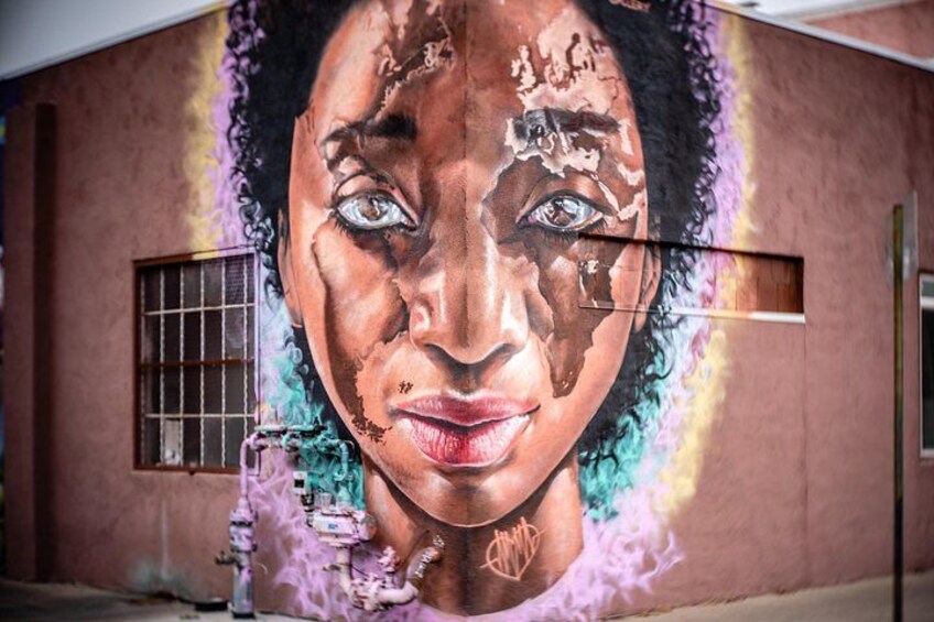 Un mural en una pared con una ventana y grafitis. 1