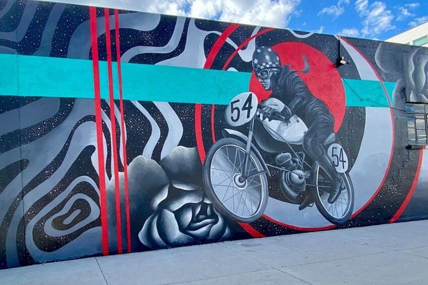 Un mural muestra a un ciclista con el número 54 en una pared. 5
