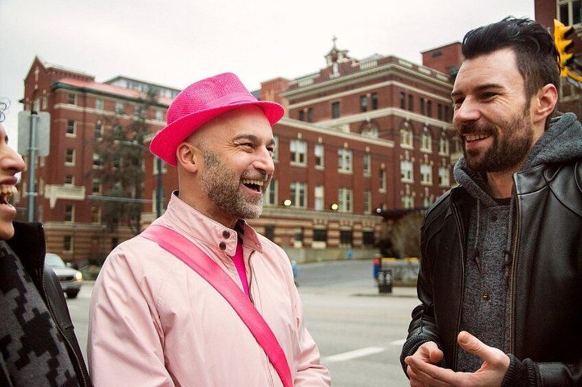 A person in a pink jacket and hat standing on a street with buildings in the background. 4
