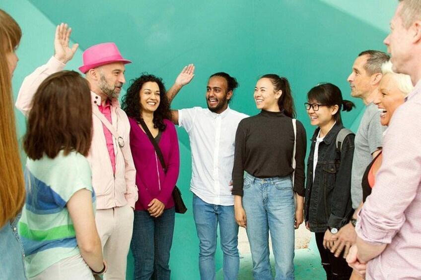 A group of people standing in a circle, some raising their hands. 3