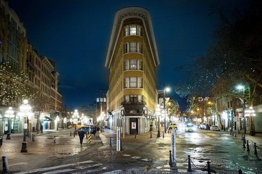 Une rue de la ville de nuit, avec un pavé mouillé, des bâtiments illuminés et des lampadaires. 4