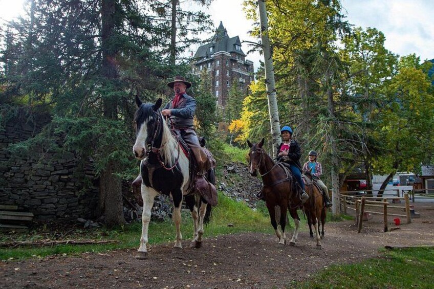 Deux personnes à cheval, sur un chemin de terre bordé d’arbres et d’un mur de pierres. 3
