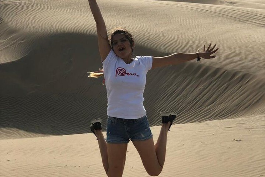 Une personne sautant dans un désert, avec des dunes de sable en arrière-plan. 4