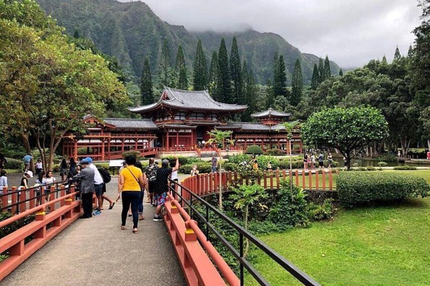 A traditional Japanese temple with visitors on a bridge. 2
