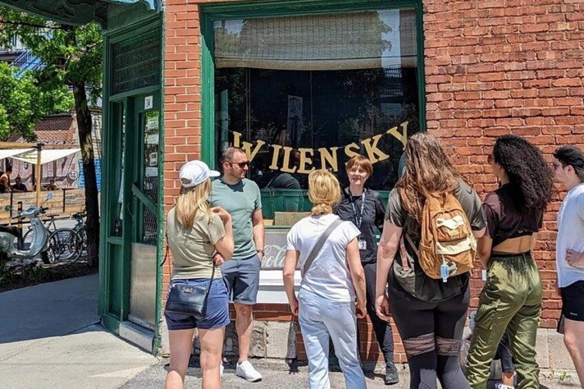 Un grupo de personas de pie frente a un edificio con un letrero que dice 'IVIENSKY'. 2