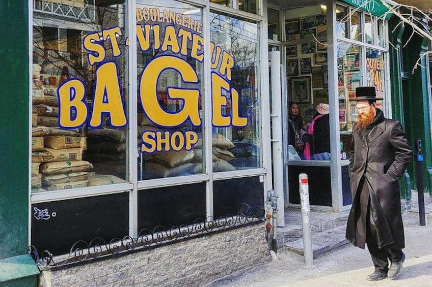 Ein Laden mit einem Schild, auf dem 'St. Vincent Bagel Shop' steht, und einer Person, die davor steht. 3