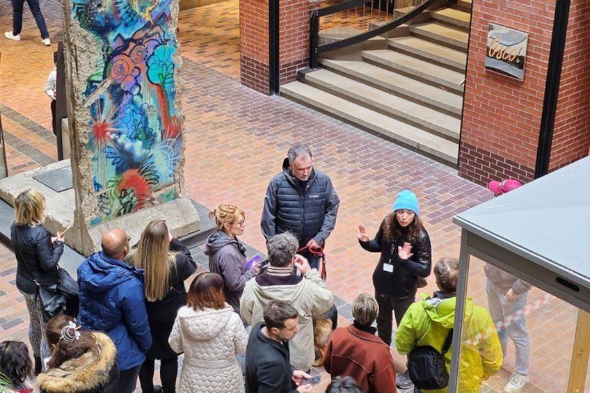 A group of people gathered around a colorful mural on a brick wall. 5
