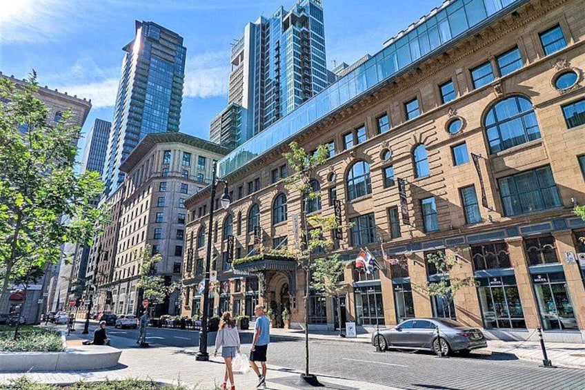 A city street with historic buildings, modern skyscrapers, and pedestrians. 3