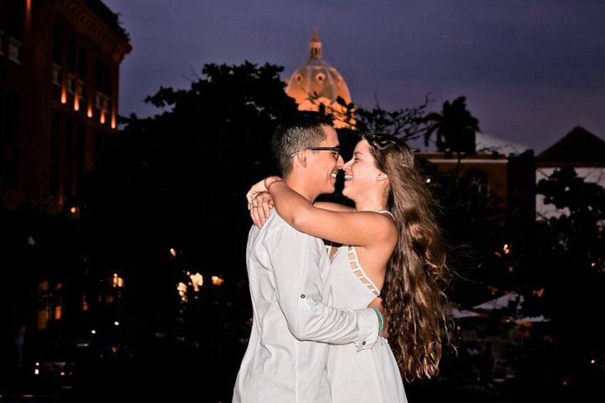 A couple embracing in front of a building with a dome at dusk. 4