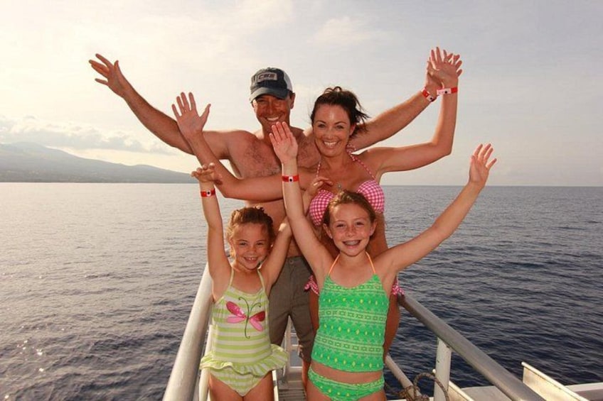 A family on a boat with the sea and mountains in the background. 4