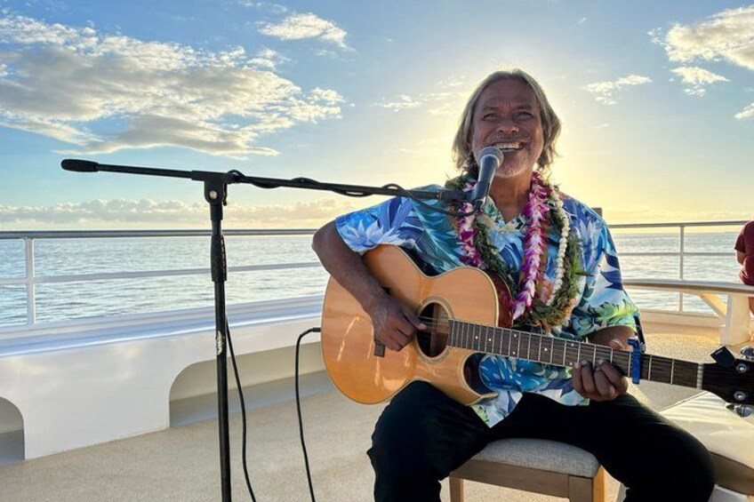 A person playing a guitar on a boat with a microphone stand in front of them. 4