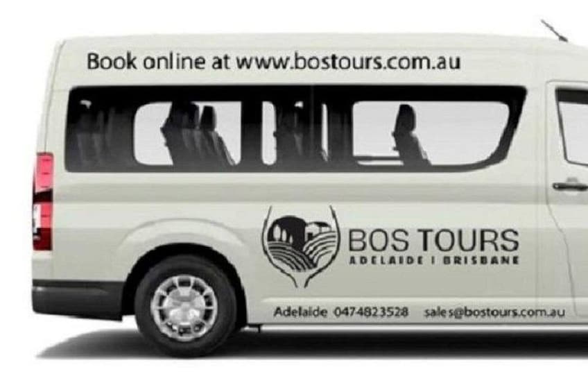 Un fourgon blanc avec l’inscription « BOS TOURS » et les coordonnées. 2