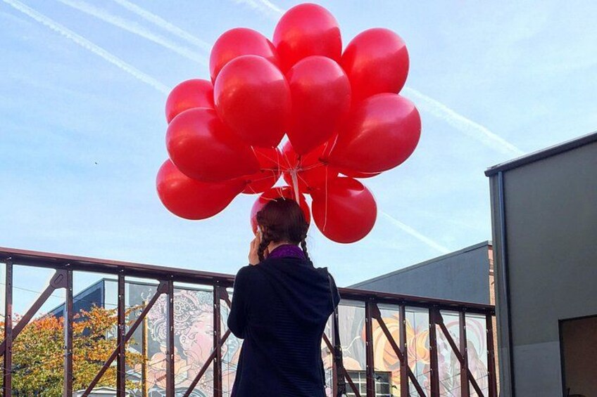 A person holding a bunch of red balloons. 5