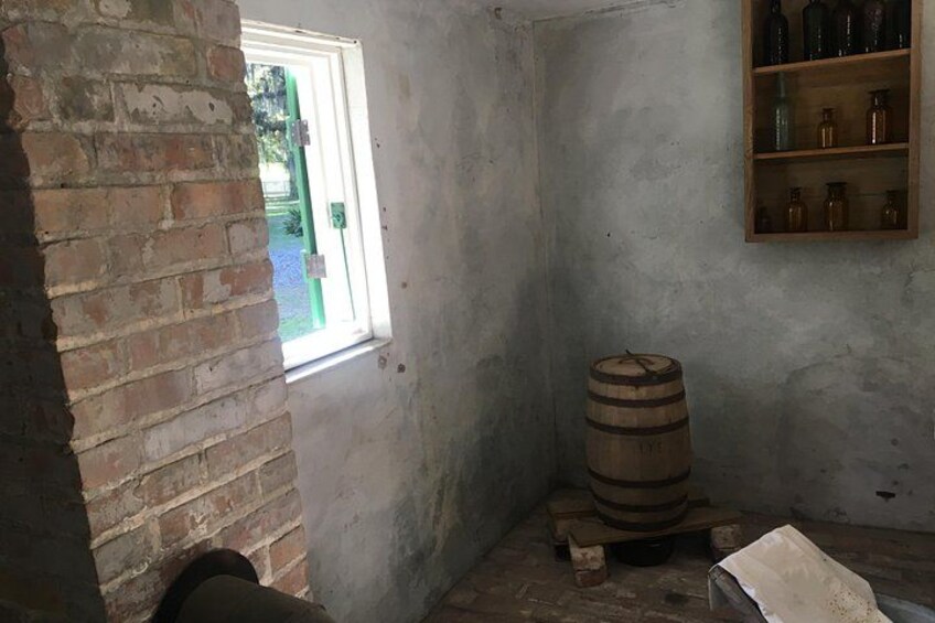 Een rustieke kamer met een houten vat, een bakstenen muur en een houten plank met flessen. 5