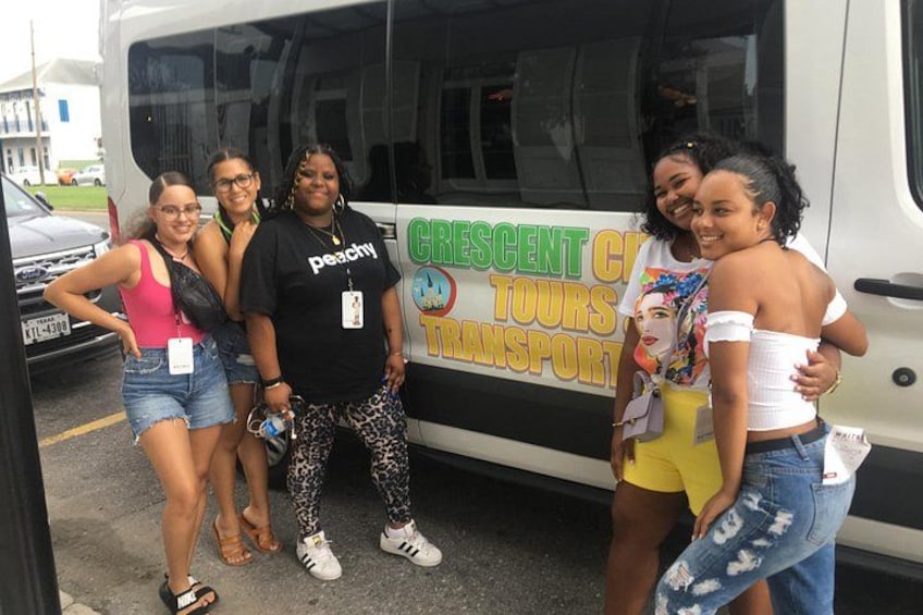 Een groep mensen staat voor een bus met een bord 'Crescent City Tours Transport'. 5