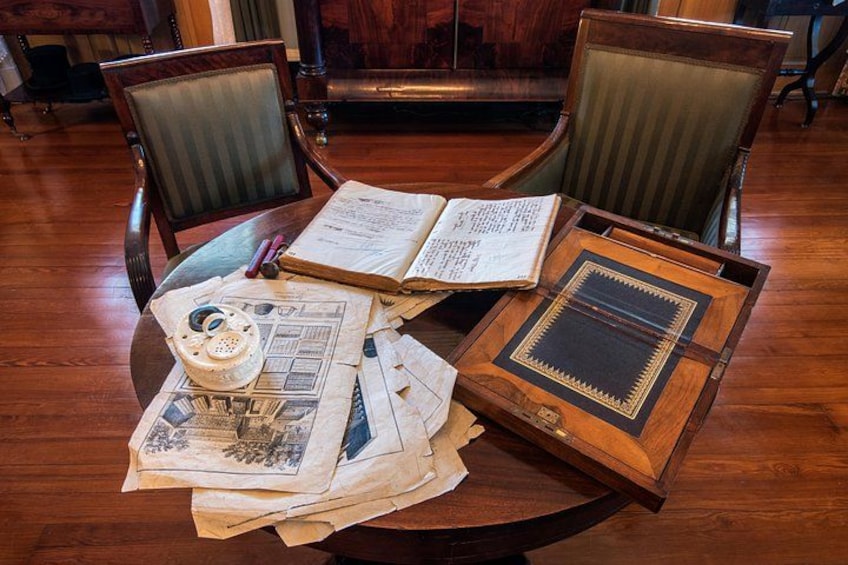 An open book on a wooden table, surrounded by papers and a vintage rotary phone. 5