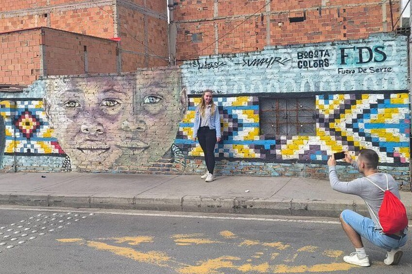 A mural on a brick wall with a person taking a photo. 5