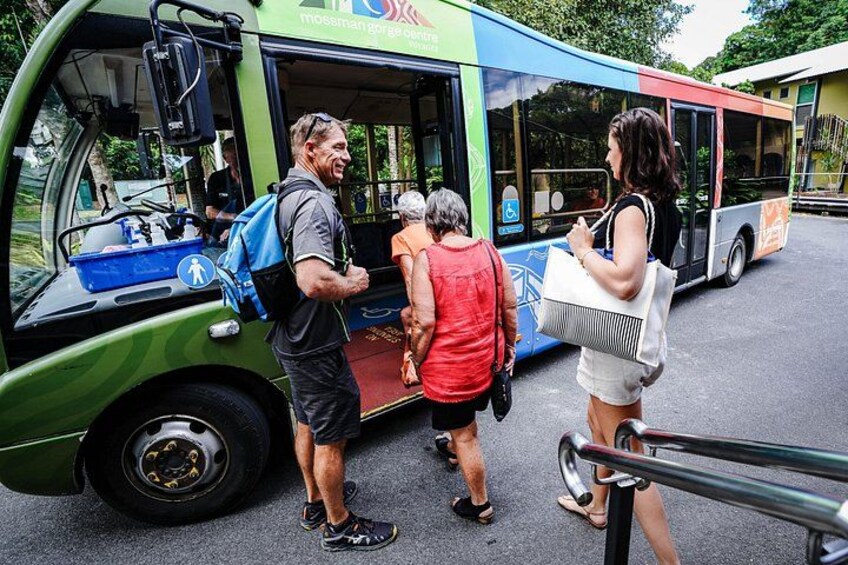 A green bus with people boarding and alighting. 4