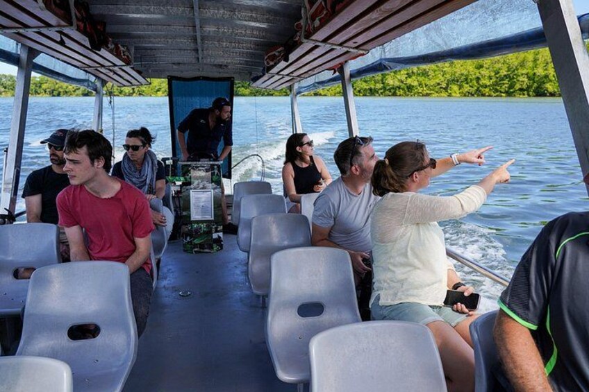 People on a boat, some pointing towards the water. 1