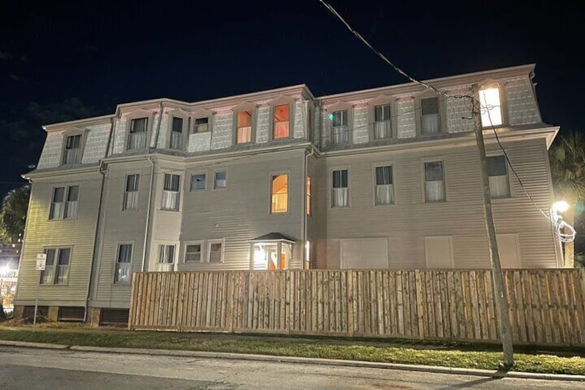 A multi-story building with illuminated windows at night. 2