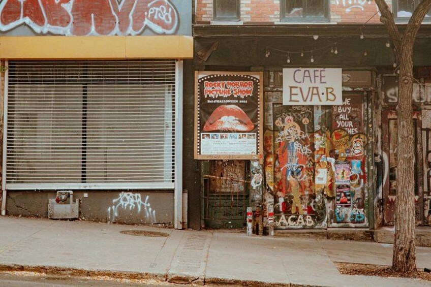Une devanture de magasin ornée d’une enseigne sur le thème d’Halloween, avec un volet fermé et divers affiches et décorations. 4